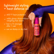 Amika Superfruit Star lightweight styling oil bottle held beside brown hair