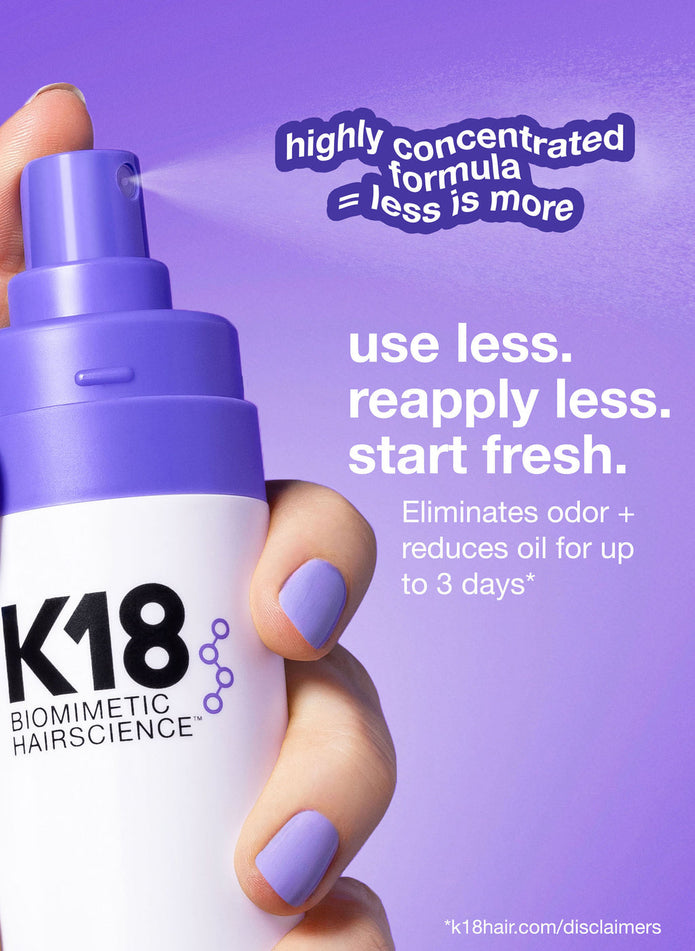 K18 AirWash dry shampoo bottle held by fingers with purple manicure