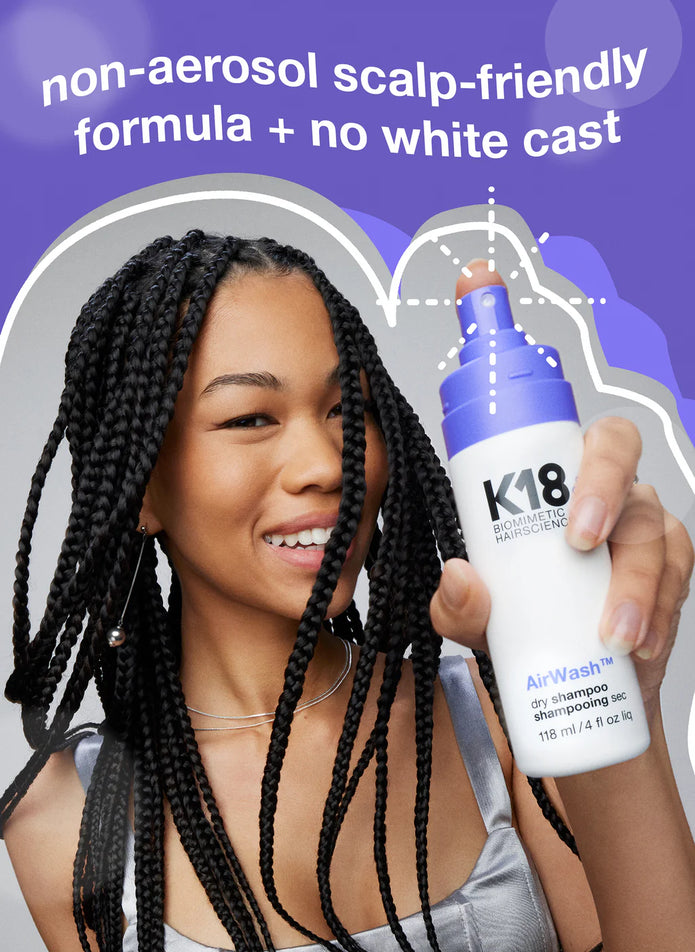 K18 AirWash dry shampoo bottle held up by hand, braided hair visible