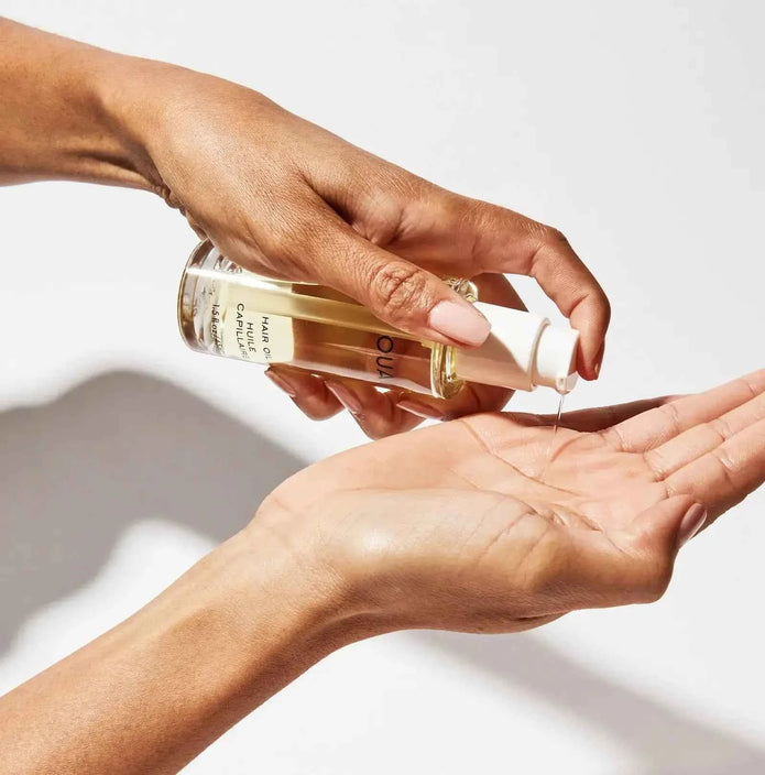 Ouai hair oil poured from bottle into palm