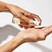 Ouai hair oil poured from bottle into palm