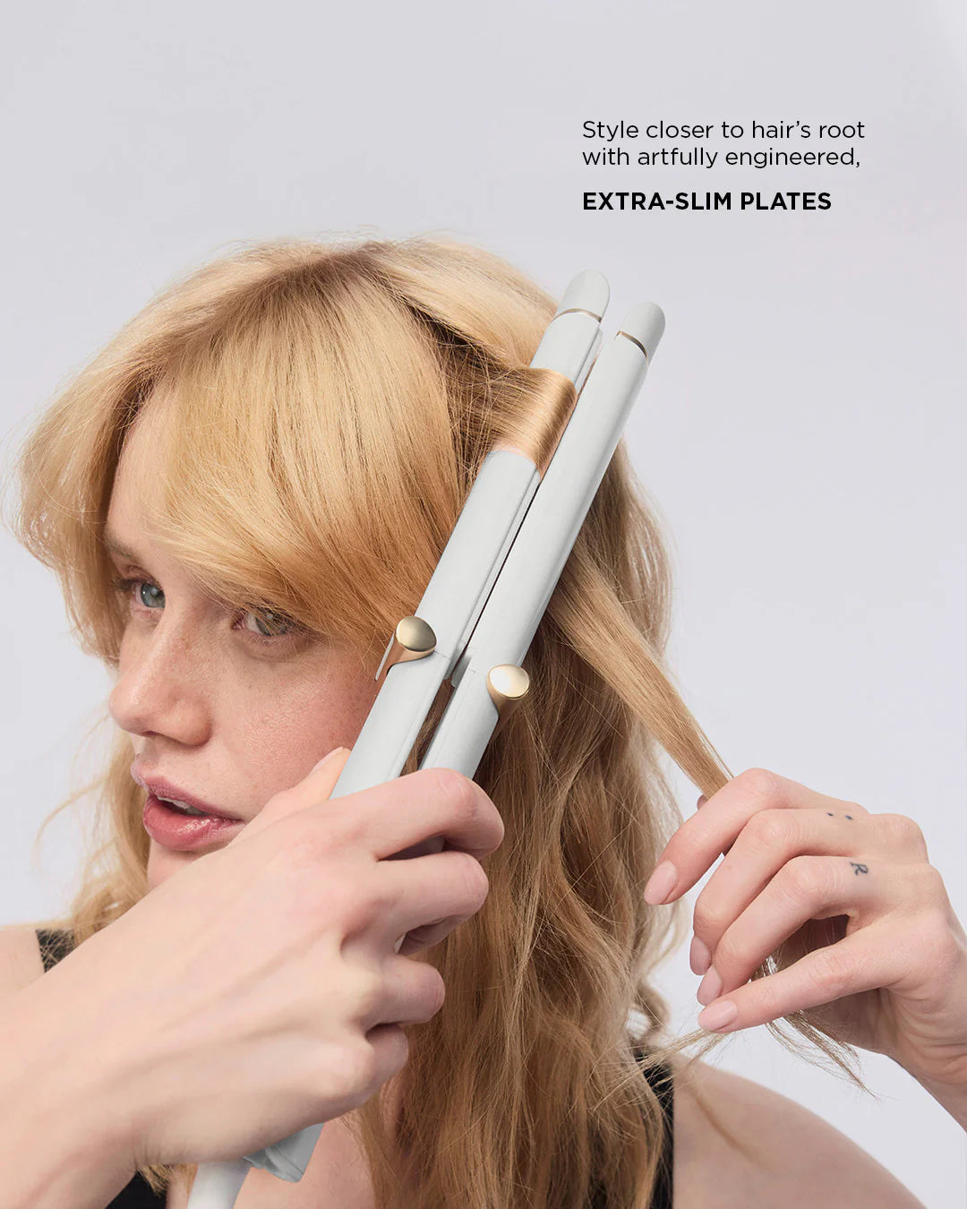White T3 curling straightener styling blonde hair near the roots, close-up