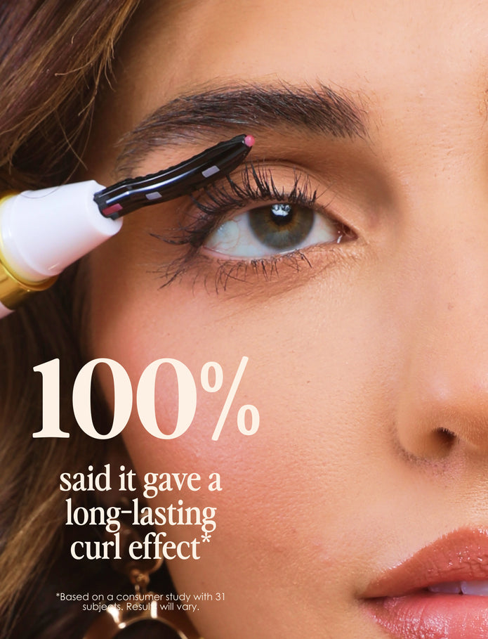 Black heated comb tool lifting lashes at the lash line on a close-up eye