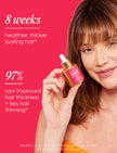 Hair Enhancing Serum bottle with dropper held beside long brown hair