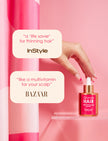Hair Enhancing Serum bottle with gold pump held near pink column