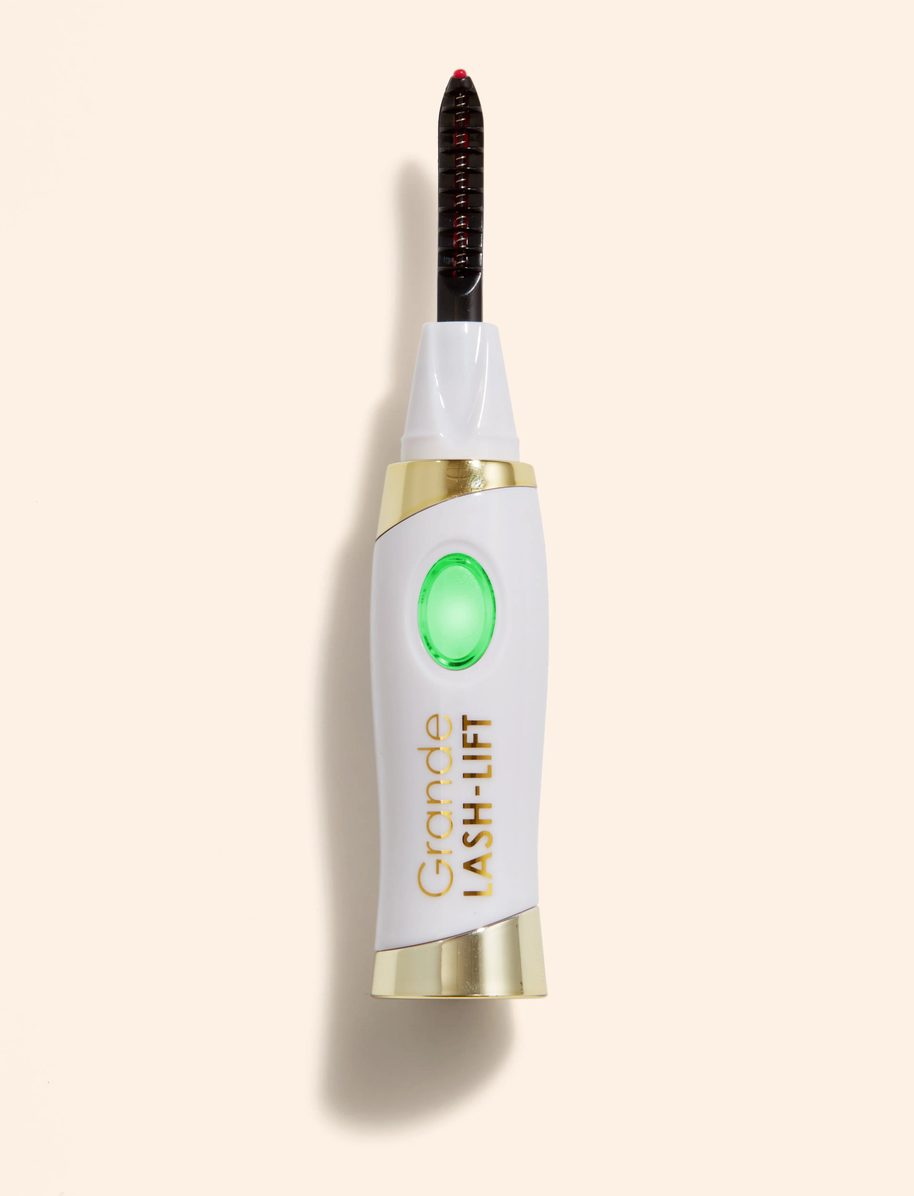 White and gold heated lash curler with black comb and green heat indicator