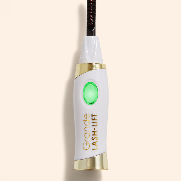 White and gold heated lash curler with black comb and green heat indicator