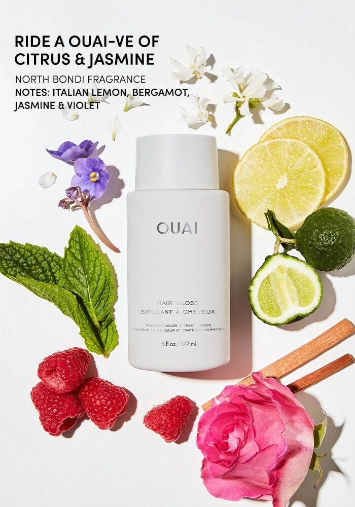 Hair gloss bottle with lemon, flowers, and fruit on display
