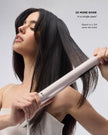 Hair straightener used on long black hair, glossy straightened strands