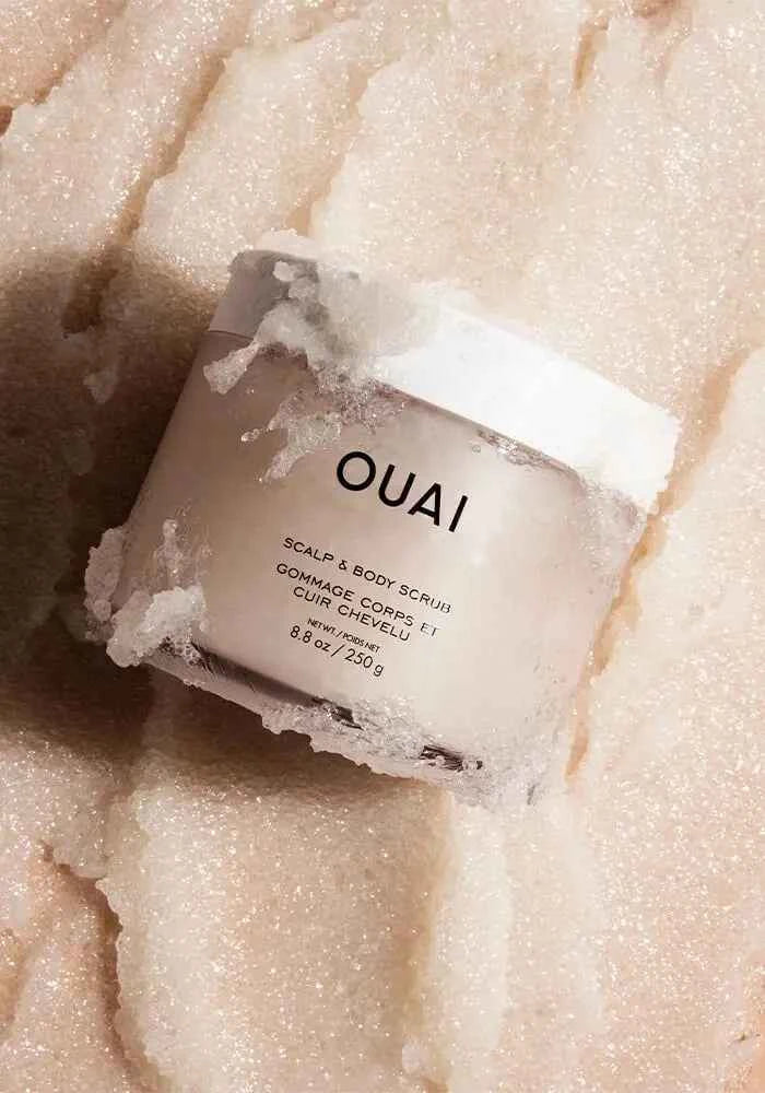 Ouai scalp and body scrub jar with white label, with pale exfoliating crystals