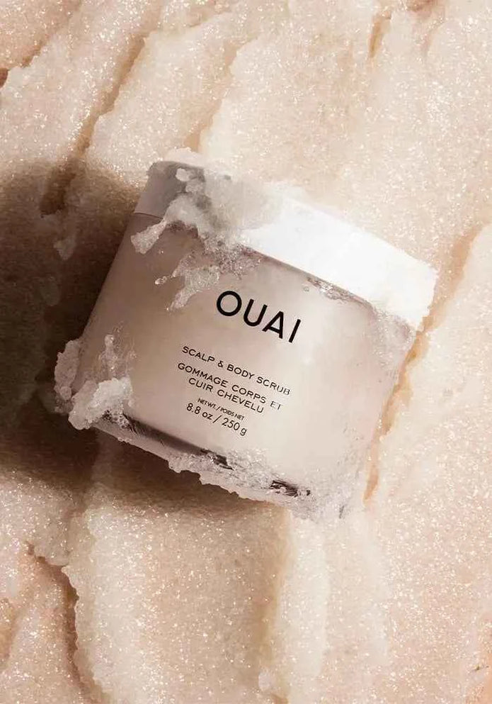 Ouai scalp and body scrub jar with white label, with pale exfoliating crystals