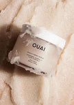 Ouai scalp and body scrub jar with white label, with pale exfoliating crystals