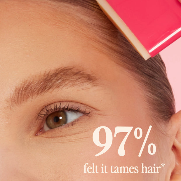 Pink Slick Back taming stick held near hairline for slick, styled look