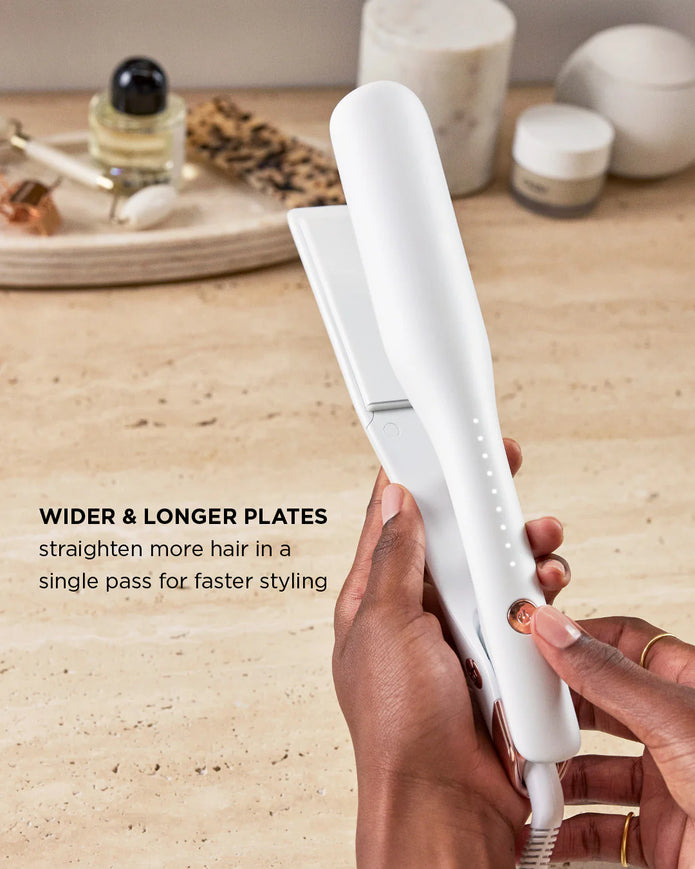 White straightening iron held in hand, showing long plates for quick styling