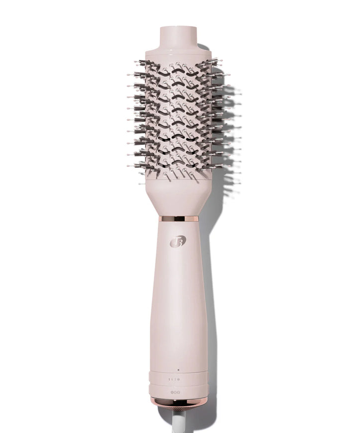 Satin blush heated brush styler with dense black bristles on a pink handle base