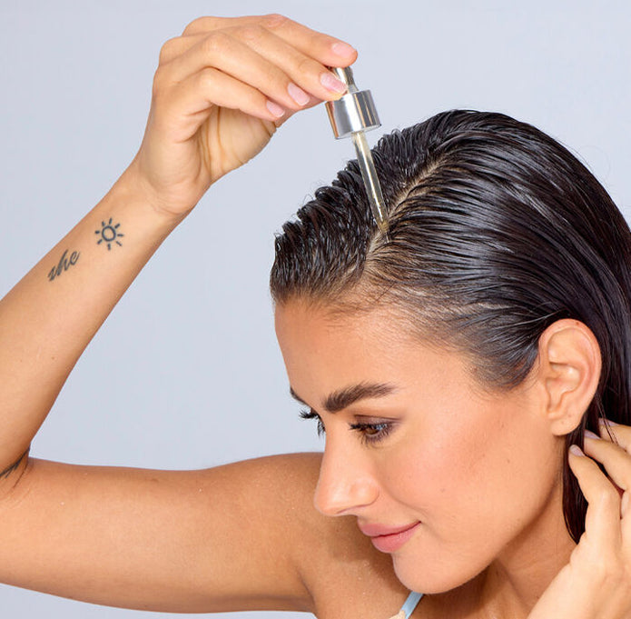 Youth Juice scalp treatment applied to hair part with dropper