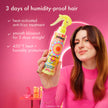 Hand holding yellow anti-frizz treatment spray bottle above smooth, glossy hair